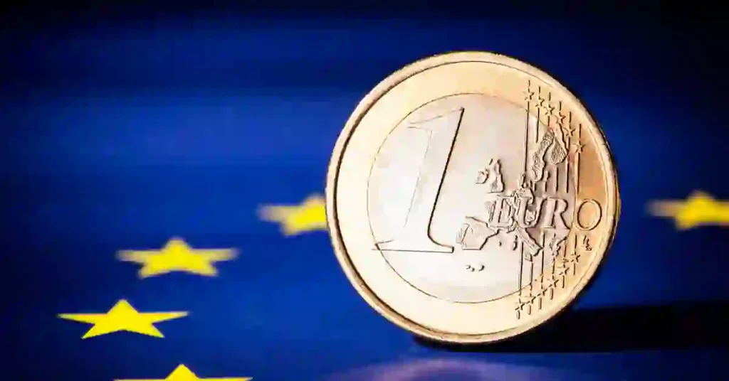 Moneda de 1 euro sobre la bandera de la Unión Europea, representando el papel del Banco Central Europeo en la política monetaria